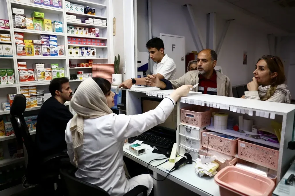 Consumidor segurando sacola de medicamentos descendo escadaria de drogaria em Teerã