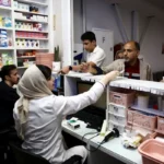Consumidor segurando sacola de medicamentos descendo escadaria de drogaria em Teerã